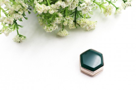 Caixa de comprimidos hexagonal em prata com pedra verde na tampa